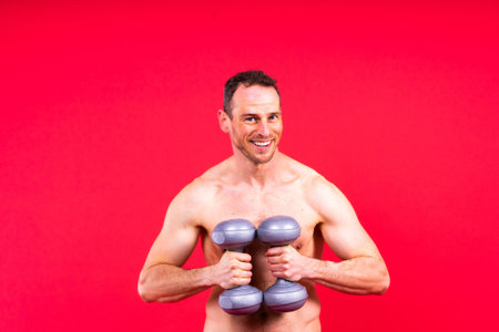 Man, dumbbell and exercise in studio for fitness, wellness and healthy body with workout training.の写真素材