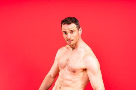 Handsome bodybuldier man posing showing muscle, shirtless torso showing pectorals and sixpackの写真素材