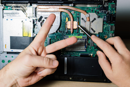 Service engineer install new chips to laptop. Repairing and upgrading laptop concept. Close up view.