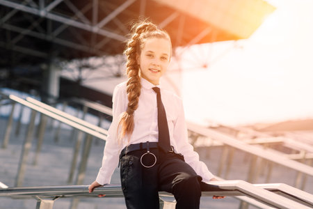 Young schoolgirl in a white classical blouse posing in the cityの写真素材