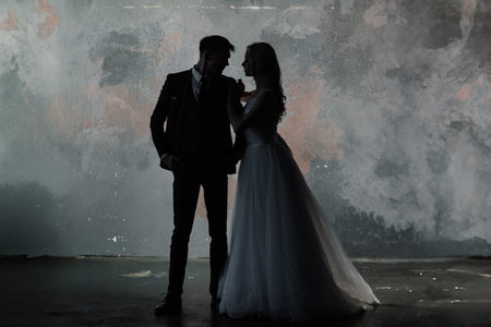 Art fashion studio photo of wedding couple silhouette groom and bride on colors background. Art...