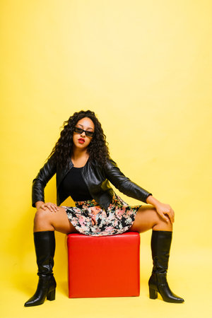 Seductive african woman posing in black bodysuit and jacket in studio. Fit sporty female.の写真素材