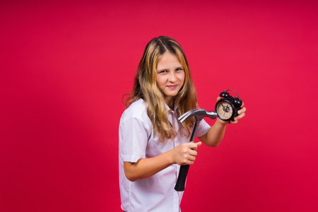 Teen girl 12, 13, 14 years old look alarm clock. Good morning, checking time. Positive emotions.の写真素材
