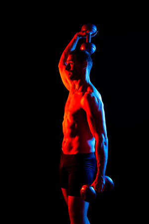 Adult muscular man working out hard with a dumbbell.の写真素材