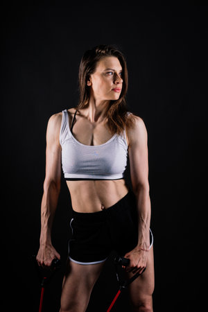 Athletic female performs exercises using resistance band. Strength and motivationの写真素材