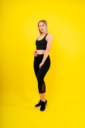 Portrait, fitness or body of young woman in studio isolated on yellow black red background.の写真素材