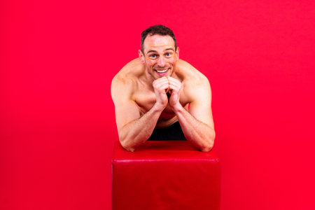 Image of man posing in a studio, dark red backgroundの写真素材