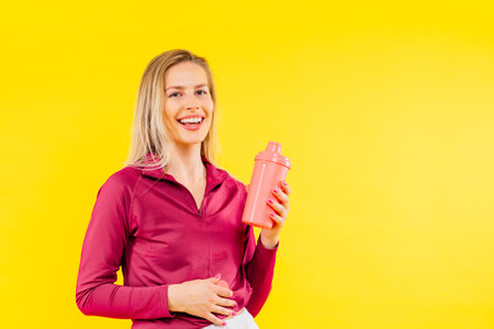 Attractive woman and water bottle for body diet, health and wellness against studio background.の写真素材