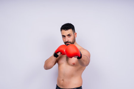 Man boxer in red sport boxing gloves at a studio, copy space.の写真素材