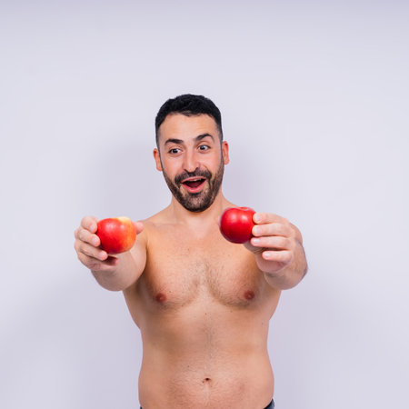 Man, hands and holding apple on white background in a studio for health, wellness or immune support.の写真素材