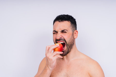 Man, hands and holding apple on white background in a studio for health, wellness or immune support.の写真素材