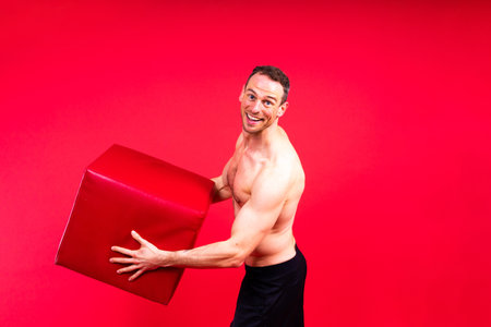 Portrait, happy man and bodybuilder with abs on a studio background, backdrop and topless prideの写真素材
