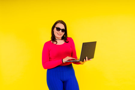 Full length photo of a young smiling fat overweight woman wearing sportswearの写真素材