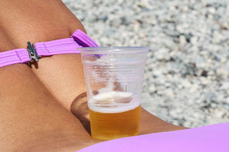Glass of fresh beer on a girl backの写真素材