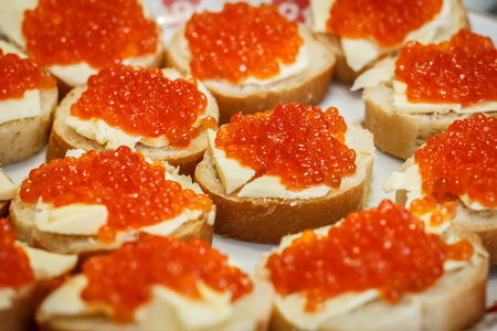 Many small sandwiches with red caviarの写真素材