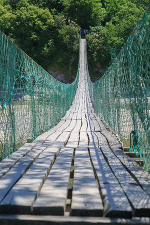 Hanging walking bridge across gorge of the riverの写真素材