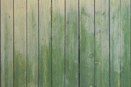 Old vertical boards spotty painted green paint as backgroundの写真素材