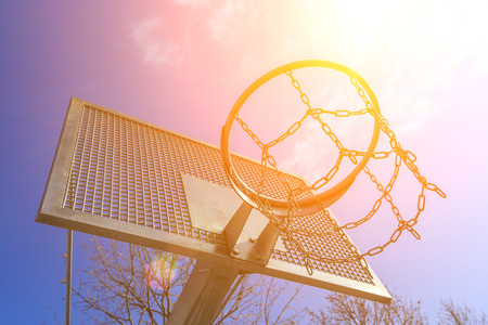 Modern metal extra strong basketball ring on the sport ground on the background of the blue sky and sunの写真素材