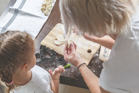 Mom shows little daughter how to make dumplingsの写真素材