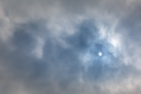 A disk of the sun or moon in the cloudy sky