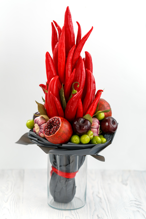 Bouquet of red pepper, pomegranates, blue plums, laurel leaves and rose flowers as set for the preparation of Georgian tkemali sauceの写真素材