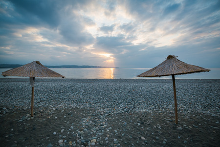 Umbrellas with a cane roof on the beachの写真素材