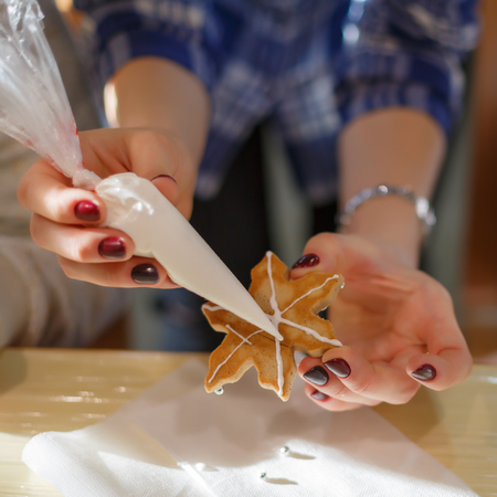 Woman shows how to decorate the cookiesの写真素材