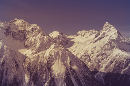 Steep peaks of the Caucasus Mountains. Toned image in purple color