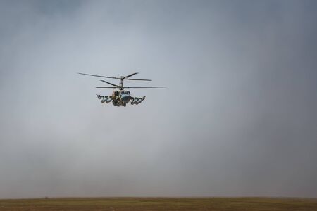 KADAMOVSKIY TRAINING GROUND, ROSTOV REGION, RUSSIA, 26 AUGUST 2018: International military technical forum ARMY-2018. Attack helicopter Ka-52 Alligator, the flying tank, flies above the groundのeditorial素材