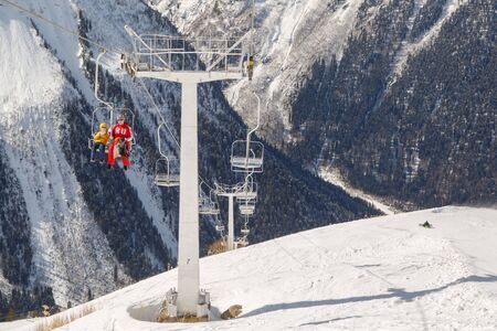 DOMBAI, RUSSIA, FEBRUARY 27, 2018: Double-chair ski lift with peopleのeditorial素材