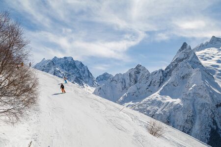 DOMBAY, RUSSIA, FEBRUARY 27, 2018: Skiers ride on the ski pisteのeditorial素材
