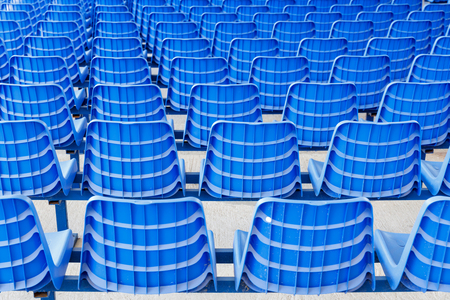Rows of blue plastic chairs on a metal base. Back viewの写真素材