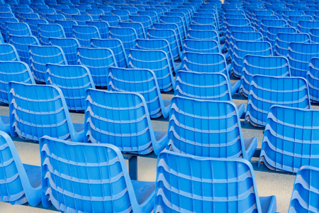Rows of blue plastic chairs on a metal baseの写真素材