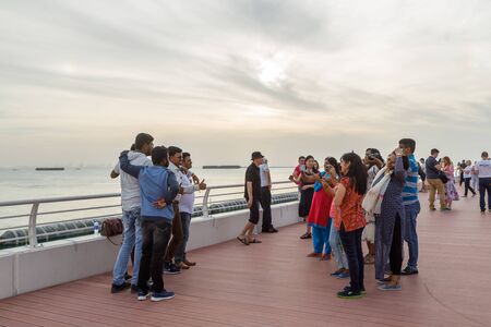 DUBAI, UAE, JANUARY 13, 2019: Smiling and happy tourists are photographed on the waterfront in the eveningのeditorial素材