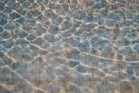 Old faded tiles in a dirty pool as a background.