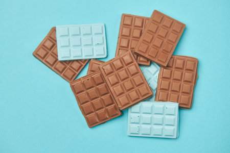 Handmade milk chocolate on a turquoise background.
