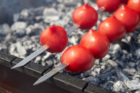 Red ripe tomatoes are fried on skewers to prepare a further delicious sauce.の写真素材