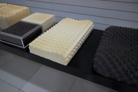 Several types of different natural latex pillows are in the show room of a factory.