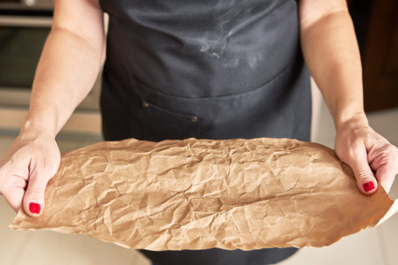 Woman holds eco-friendly craft paper in her hands for subsequent gift wrapping.
