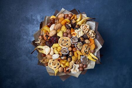 Healthy bouquet of dried fruits and nuts, top view on a dark blue background.の写真素材