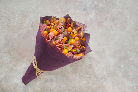 Tasty edible bouquet consisting of sausages, cheese and tomatoes on a light background.の写真素材