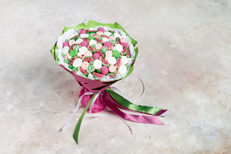 A small bouquet of candies and marshmallows for a child on a gray backgroundの写真素材