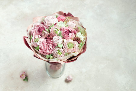 Beautiful bouquet of pink marshmallow handmade stands in a vase on a light backgroundの写真素材