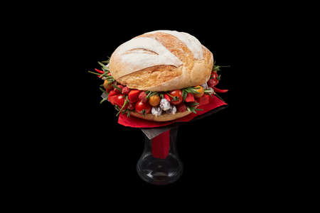 Bouquet of sausage, cheese and tomatoes. decorated in the form of a large sandwich on a black backgroundの写真素材
