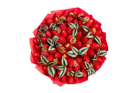 Bright bouquet of ripe strawberries wrapped in red paper on a gray background. top viewの写真素材