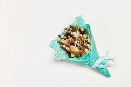 Turquoise bouquet made of dried fish and snacks on a white backgroundの写真素材