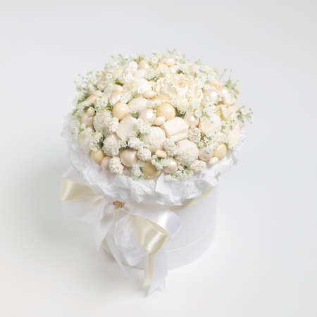 White box filled with white chocolate sweets on a white backgroundの写真素材