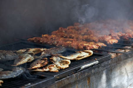 A lot of various fish is prepared on a large grill for a large partyの写真素材