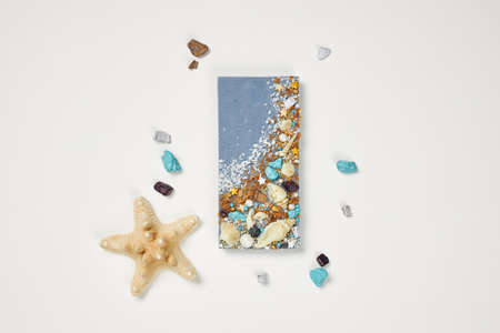 Bar of blue chocolate decorated with sea shellsの写真素材