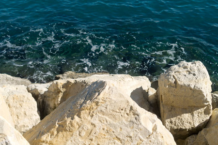 Close-up of white rocky cliff and blue sea water below